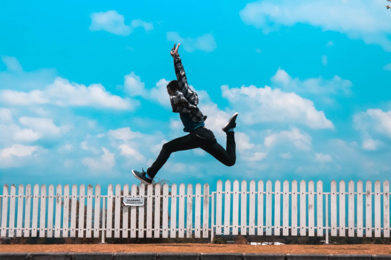 Photo of a person jumping over a fence